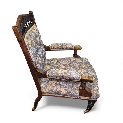 Side view of Victorian oak nursing chair showing turned arm supports and castors